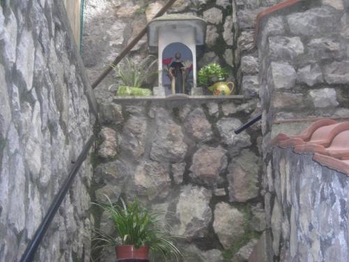 a stone wall with a statue on a shelf at B&B L'Arcobaleno in Sorrento