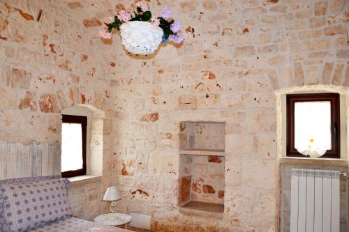 モノーポリにあるCasale del Gelsoの石壁とシャンデリアのある部屋