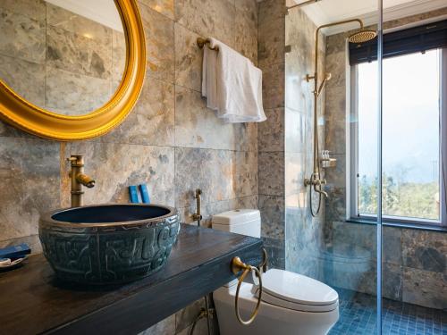 bagno con lavandino, servizi igienici e specchio di Aliana Boutique Sapa Hotel & Spa a Sa Pa