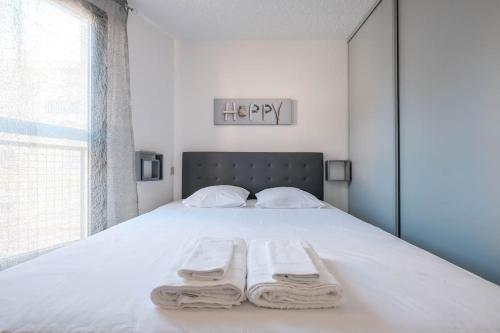 カンヌにあるAppartement Suquet à Cannesのベッドルーム1室(白いベッド1台、タオル2枚付)