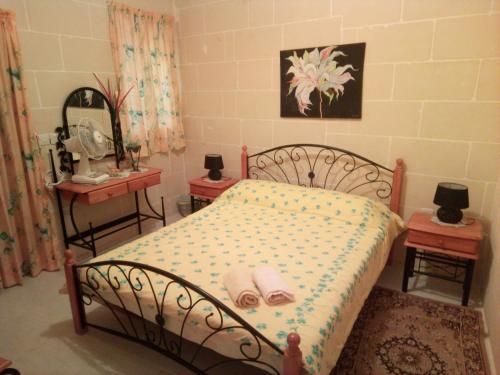 a bedroom with a bed with two tables and a mirror at Coral Reef Flat 7 in Marsalforn