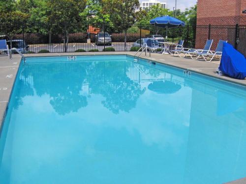 a large blue swimming pool with chairs and an umbrella at Extended Stay America Select Suites - Atlanta - Vinings in Atlanta