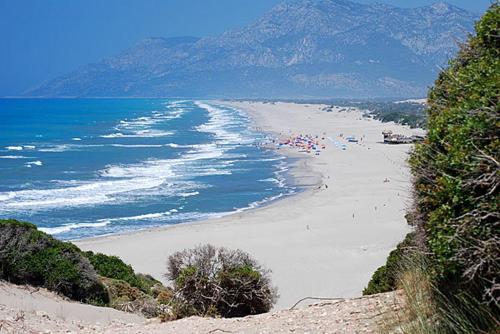 a beach with umbrellas and people on the sand at Jet Pension in Patara