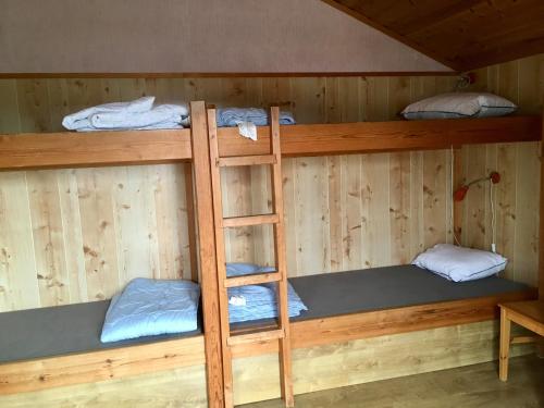 a bunk bed in a cabin with three bunk beds at Årsunda Strandbad Sjösunda vandrarhem in Årsunda