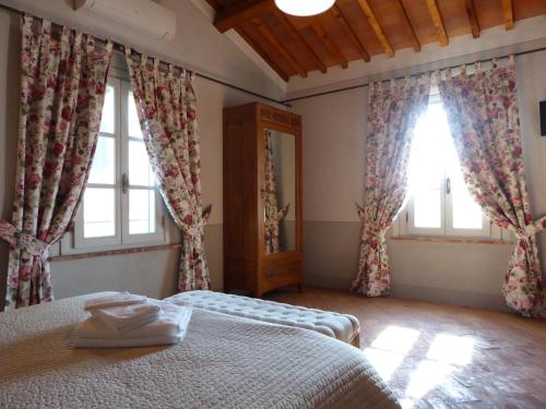 a bedroom with a bed and two windows at Casa Vacanze Villa Cerine in Altopascio