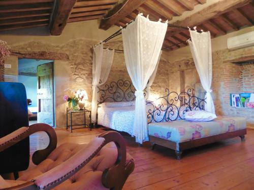 1 Schlafzimmer mit 2 Betten und 2 Stühlen in der Unterkunft Agriturismo I Pitti in Serravalle Pistoiese