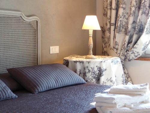a bedroom with a bed and a table with a lamp at Casa Vacanze Villa Cerine in Altopascio