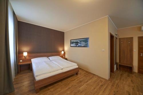a bedroom with a white bed in a room at Penzion Club in Skalica