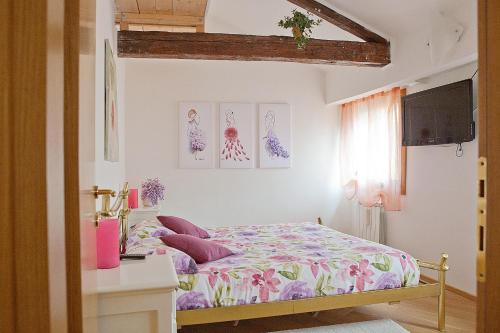 1 dormitorio con 1 cama con almohadas rosas y moradas en Appartamento Calle dei Preti info at yourhomefromhomeinvenice-venicerentalapartments dot it, en Venecia