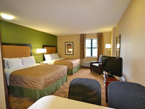a hotel room with two beds and a flat screen tv at Extended Stay America Select Suites - Detroit - Farmington Hills in Farmington Hills