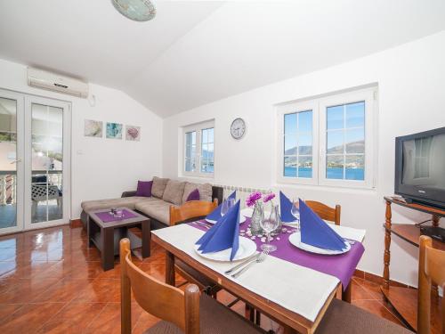 a living room with a table and a tv at Apartments Elena in Tivat