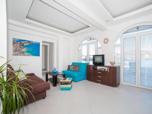 a living room with a blue couch and a tv at Apartments Elena in Tivat