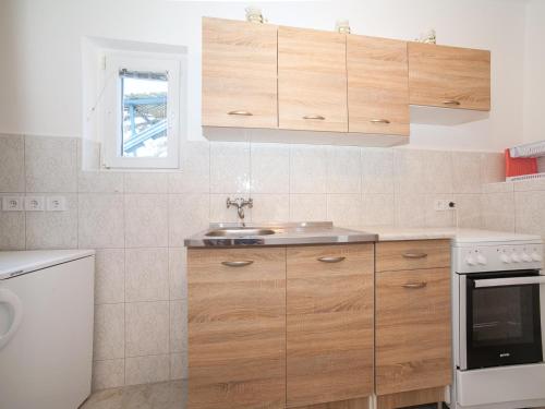 a kitchen with wooden cabinets and a sink at Apartments Elena in Tivat