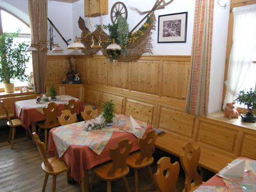 a dining room with two tables and chairs at Landgasthof und Hotel Forchhammer in Pliening