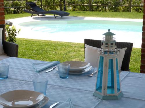 uma mesa com um farol ao lado de uma piscina em Casa Vacanze Villa Cerine em Altopascio