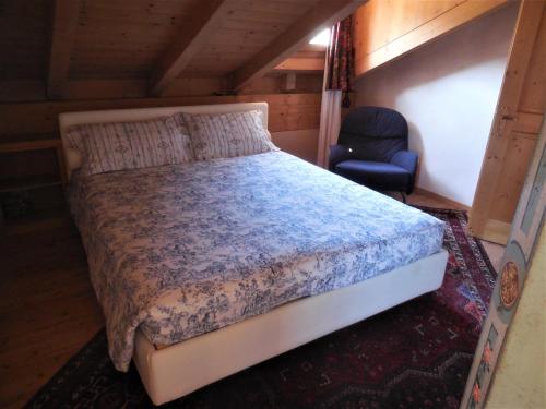 - une chambre avec un lit et une chaise dans l'établissement TorreBar, à Predazzo