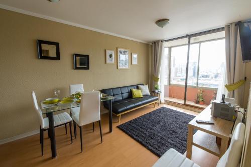 a living room with a couch and a dining room table at EcoApart Concepción in Concepción