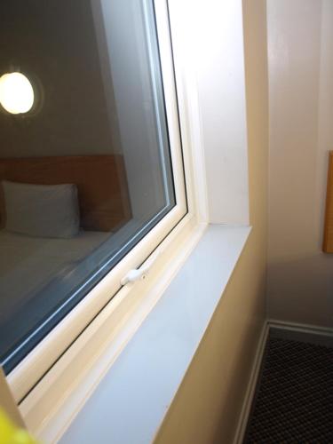 a window sill in a room with a bed at 247Hotel in Oldham