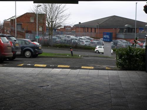 a parking lot with cars parked in a parking lot at 247Hotel in Oldham