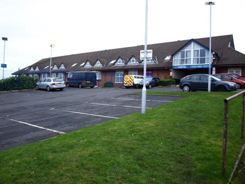 a parking lot with cars parked in front of a building at 247Hotel in Oldham