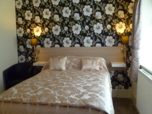 a bedroom with a bed with a floral wallpaper at Greenlaw Guest House in Gretna Green