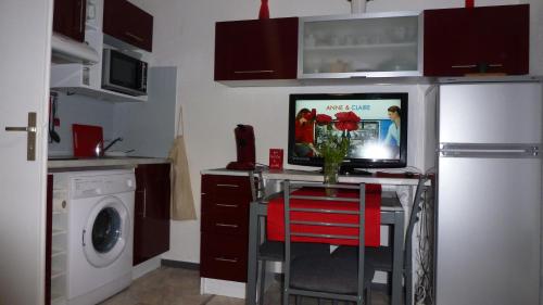 une cuisine avec une table avec un vase de fleurs dessus dans l'établissement Studio meublé, à Luchon