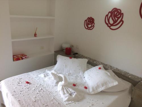 a bedroom with a bed with white sheets and pillows at Pousada Pé na Areia Guarujá in Guarujá