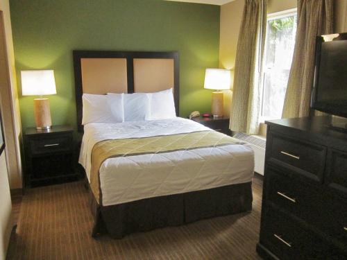 a bedroom with a bed with two night stands and a television at Extended Stay America Suites - Detroit - Novi - Orchard Hill Place in Northville