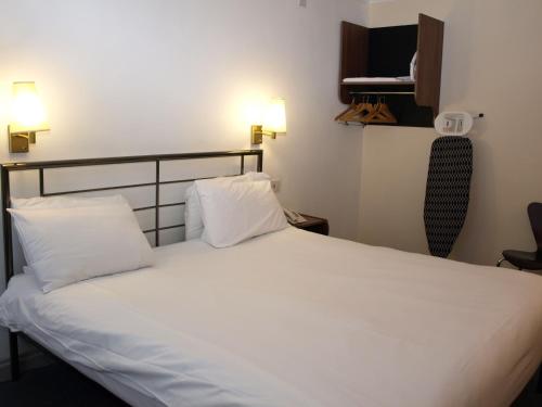 a bedroom with a white bed with two pillows at 247Hotel in Oldham