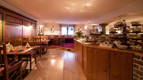 a restaurant with wooden tables and chairs and a bar at Hotel Kristall in Sankt Anton am Arlberg