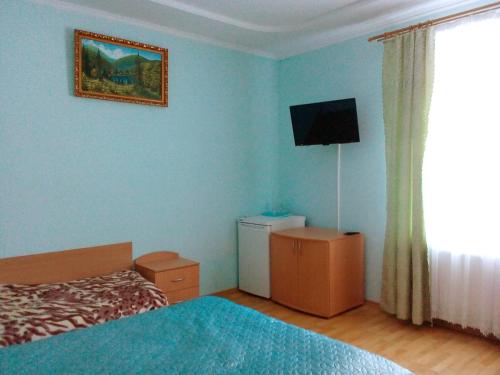 シンヤクにあるSadiba "Lisova Pisnia"のベッドルーム1室(ベッド1台、壁掛けテレビ付)
