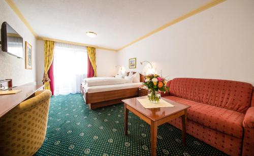 a hotel room with a couch and a bed at Hotel Kristall in Sankt Anton am Arlberg