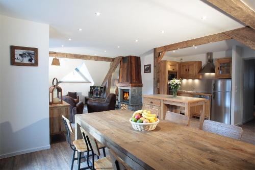 a kitchen and dining room with a table with a bowl of fruit at Chalet La Fedora - Appartements de charme in Vaujany