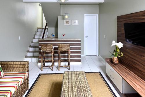 a living room with a couch and a table and chairs at Portogalo Suite Hotel in Angra dos Reis
