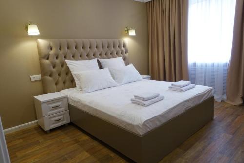 - une chambre avec un grand lit et 2 serviettes dans l'établissement KvartHaus on 40 Let Pobedy, à Togliatti