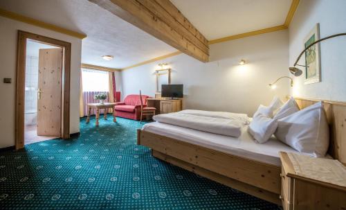 a hotel room with a bed and a living room at Hotel Kristall in Sankt Anton am Arlberg