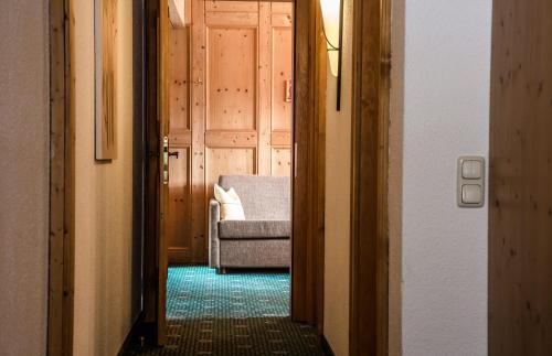 a hallway with a couch and a chair in a room at Hotel Kristall in Sankt Anton am Arlberg