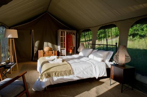Aux Lodges du Mas de Nadal في Sauliac-sur-Célé: غرفة نوم بسرير في خيمة