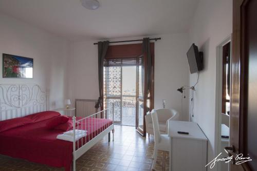a bedroom with a red bed and a balcony at Le ginestre in Salerno
