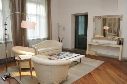 プラハにあるRoyal Road Apartmentのリビングルーム(椅子、テーブル、鏡付)