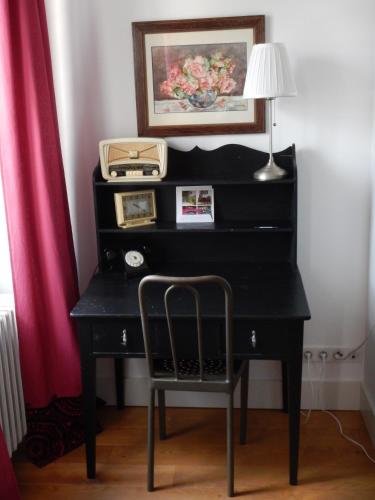 a black desk with a chair and a lamp at Le Clos de l'Abbaye in Cluny