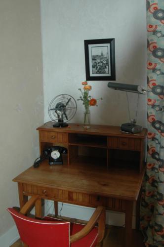 a wooden desk with a red chair and a lamp at Le Clos de l'Abbaye in Cluny