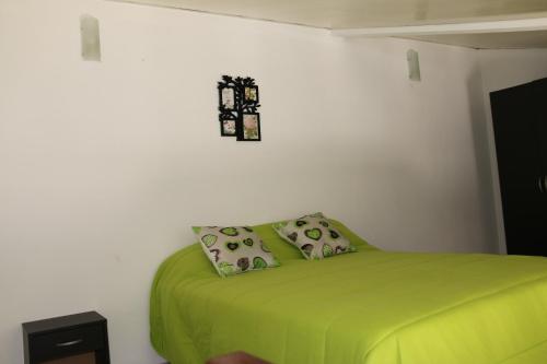 um quarto com uma cama verde e uma cruz na parede em Duplex na Nazaré na Nazaré