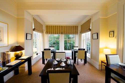 a dining room with tables and chairs and windows at The Old Rectory in Kings Lynn