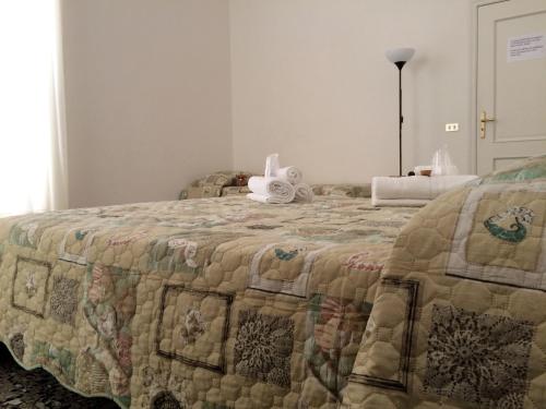 a bed with a quilt and a stuffed animal on it at B&B Zia Iaia in Siderno Marina