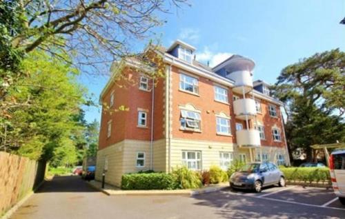 a large brick building with a car parked in front of it at Hartford Court in Bournemouth