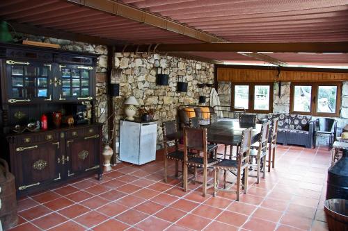 a kitchen with a table and chairs and a stone wall at Sete Quintas in Miranda do Corvo