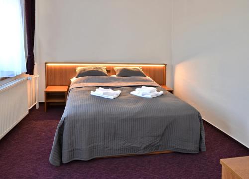 a bedroom with a bed with two towels on it at Hotel Sonata in Hradec nad Moravici