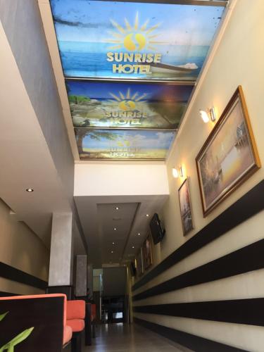 a hallway with a sun rise hotel sign on the ceiling at Sunrise Hotel Cameria in Durrës