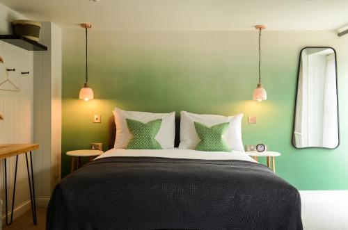 a bedroom with a large bed with green walls at The Litton in Litton
